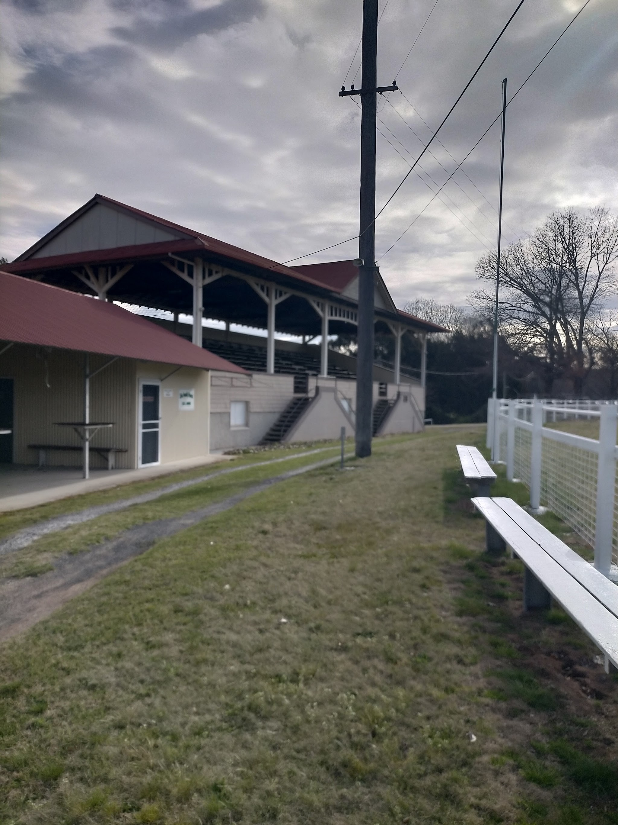 The historic grandstand and pavilion with red roofs under an overcast sky