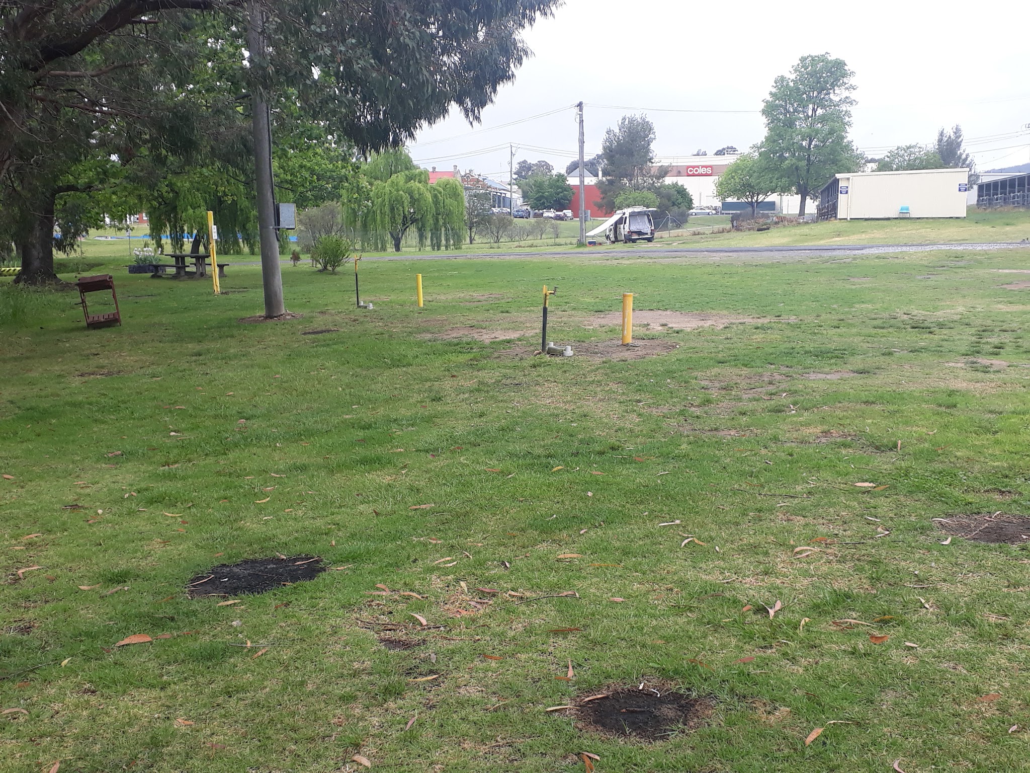 A camping site at the showground with power and water points, a picnic table and the Coles supermarket across the road